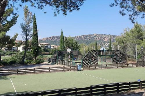 a tennis court with a tennis court at Dans un cadre d'exception, Vue mer panoramique à Agay Côte d'Azur, Village Vacances Cap Esterel, 2 chambres, avec jardin, golf, climatisation, Wifi, 5 piscines in Agay - Saint Raphael
