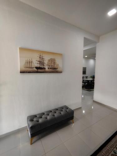 a couch in a room with a painting on a wall at Homestay Temerloh with Private Pool Near Hospital 4 Bedroom 4 Aircond 10pax Free Wi-Fi Netflix in Temerloh