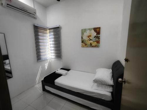 a small white room with a bed and a window at Homestay Temerloh with Private Pool Near Hospital 4 Bedroom 4 Aircond 10pax Free Wi-Fi Netflix in Temerloh