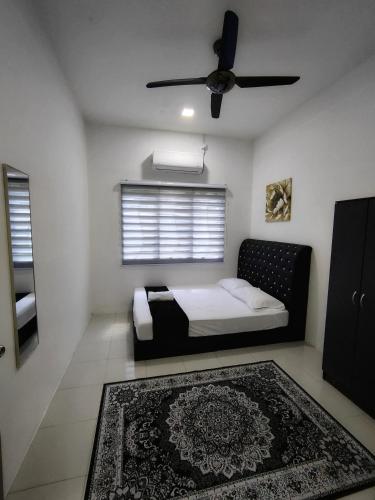 a bedroom with a bed with a ceiling fan and a rug at Homestay Temerloh with Private Pool Near Hospital 4 Bedroom 4 Aircond 10pax Free Wi-Fi Netflix in Temerloh