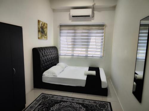 a bedroom with a bed with a black headboard and a window at Homestay Temerloh with Private Pool Near Hospital 4 Bedroom 4 Aircond 10pax Free Wi-Fi Netflix in Temerloh