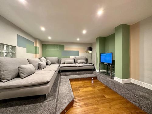 a living room with a couch and a flat screen tv at Stunning 5 bed house in Chapel Allerton, sleeps 9 in Moortown