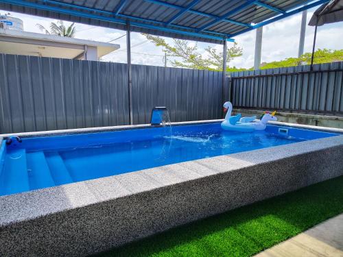 a swimming pool with a toy swan in a backyard at Homestay Temerloh with Private Pool Near Hospital 4 Bedroom 4 Aircond 10pax Free Wi-Fi Netflix in Temerloh