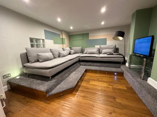 a living room with a couch and a flat screen tv at Stunning 5 bed house in Chapel Allerton, sleeps 9 in Moortown
