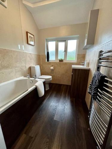 a bathroom with a tub and a toilet and a sink at Stunning 5 bed house in Chapel Allerton, sleeps 9 in Moortown