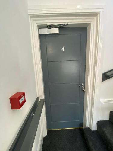 Szare drzwi w korytarzu z pudełkiem na ścianie w obiekcie Luxury Apartment APT4 w mieście Wolverhampton