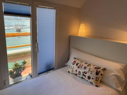 um quarto com uma cama e uma grande janela em Exclusivo ático Baiona Carabela Pinta em Baiona