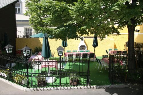 
a patio area with chairs, a fence, and a garden at Appartement Hotel Marien-Hof in Vienna
