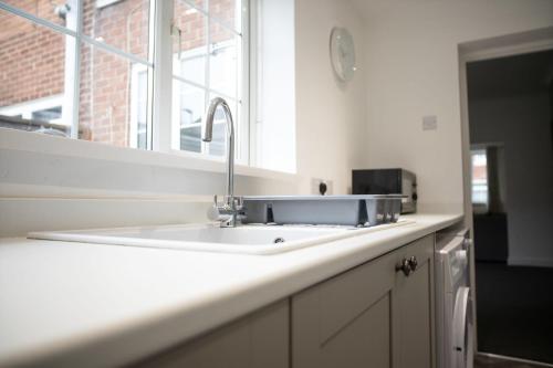 a kitchen counter with a sink and a mirror at Sleek Gem Home in Houghton le Spring, Sleeps 5 in Houghton le Spring