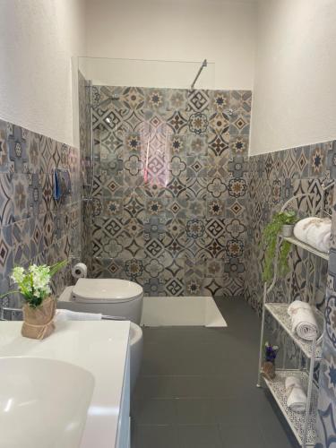 Un baño con inodoro y pared de azulejos. en St.Joseph, en Olbia