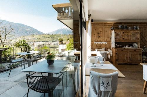 a balcony with tables and chairs and a view at Bäcksteinerhof in Merano