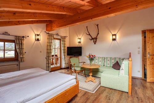 a bedroom with a bed and a couch and a table at Gästehaus Almblick in Schönau am Königssee