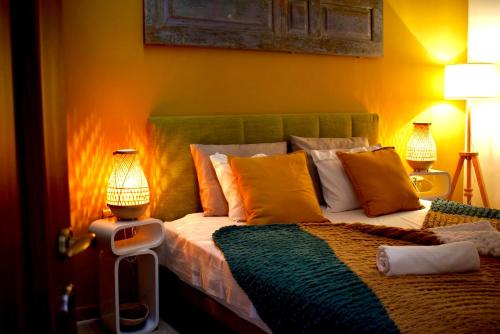 a bedroom with a bed with yellow walls and two lamps at Carmen Art Hotel in Rhodes Town