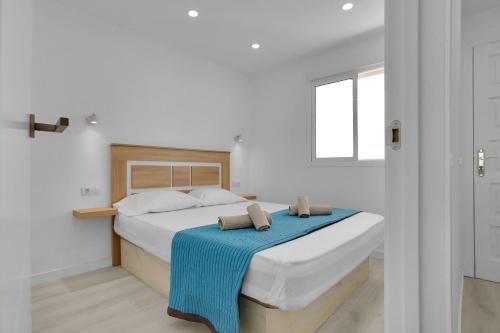 ein Schlafzimmer mit einem Bett mit einer blauen Decke darauf in der Unterkunft THE CLIFFS PENTHOUSE, Huge Terrace, Bbq, Air C in Puerto de Santiago