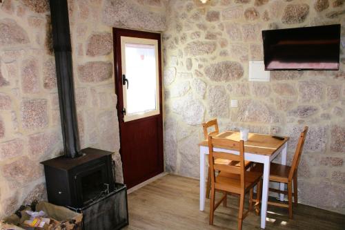 a dining room with a table and a wood stove at Casa da Cuca in Campo do Gerês