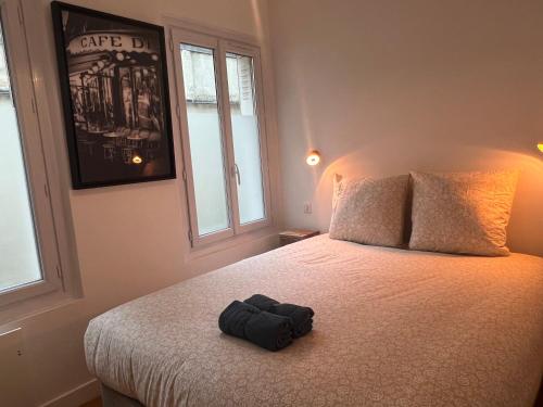 a black hat sitting on a bed in a bedroom at Loft 4 chambres Montmartre Pigalle climatisé in Paris