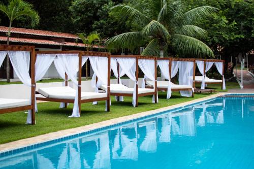 a row of lounge chairs next to a swimming pool at Verde Mar Pipa Beach in Pipa