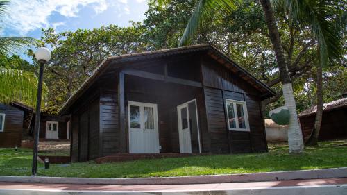 a small wooden house with a white door at Verde Mar Pipa Beach in Pipa