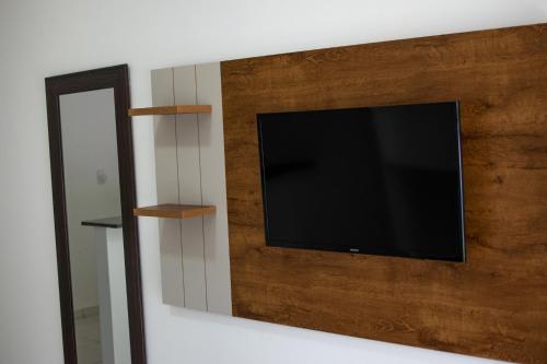 a flat screen tv on a wall with a mirror at Verde Mar Pipa Beach in Pipa
