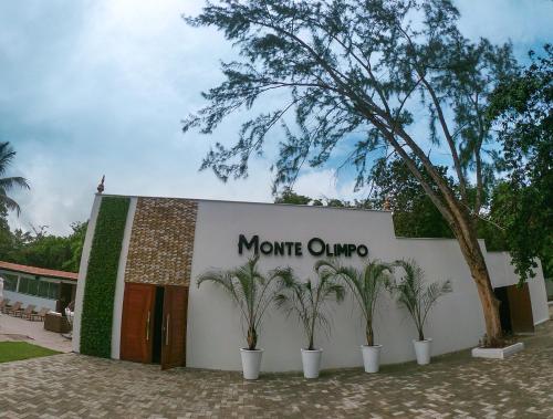 a sign on a building with palm trees in front at Verde Mar Pipa Beach in Pipa