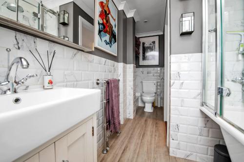 a bathroom with a sink and a toilet at Stylish 3 bedroom townhouse for 5 guests, set in the medieval grid with off street parking in Bury Saint Edmunds