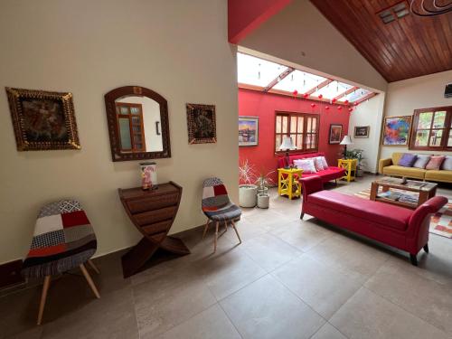 sala de estar con sofá rojo y sillas en Casa Micaela, en Iquitos