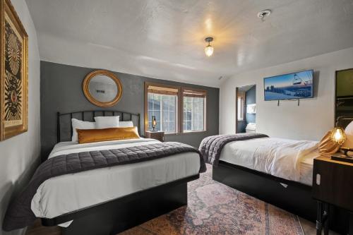 een slaapkamer met 2 bedden en een spiegel bij Sessions Retreat & Hotel in Big Bear Lake