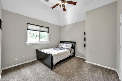 a bedroom with a bed and a ceiling fan at Taupewood Pl in The Woodlands