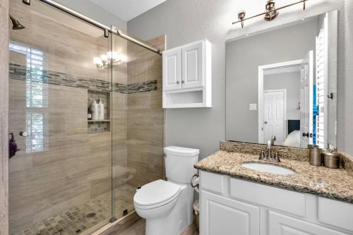 a bathroom with a toilet and a shower and a sink at Taupewood Pl in The Woodlands