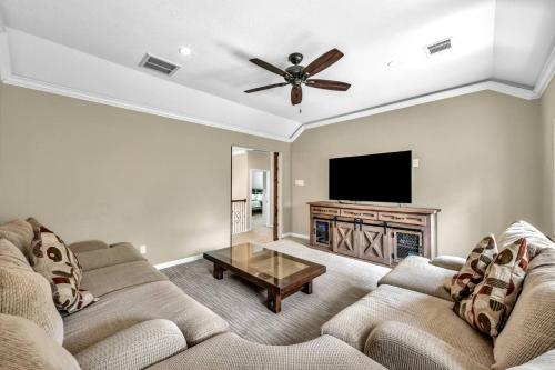 a living room with two couches and a flat screen tv at Taupewood Pl in The Woodlands