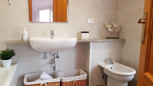 a bathroom with a sink and a toilet at Exclusivo ático Baiona Carabela Pinta in Baiona