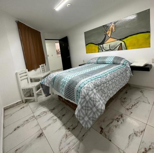 1 dormitorio con 1 cama y una pintura en la pared en Hotel Villa 12 Orquídeas, en San Juan del Río