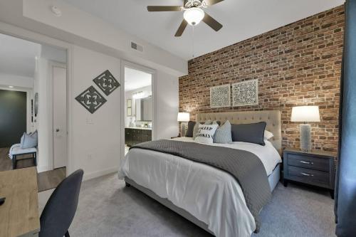 een slaapkamer met een groot bed en een bakstenen muur bij Brooklyn Suite - 627 in The Woodlands