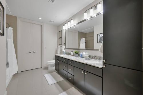 een badkamer met een wastafel, een toilet en een spiegel bij Brooklyn Suite - 627 in The Woodlands