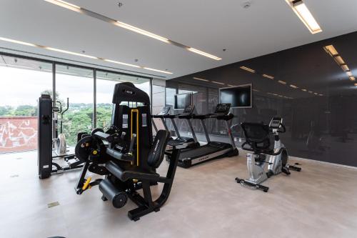 une salle de sport avec tapis de course et vélos elliptiques dans une pièce avec fenêtres dans l'établissement Parque Jockey by Viva - Prédio com fácil acesso a Pinheiros e ao Butantã, à São Paulo