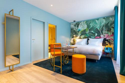 Habitación de hotel con cama, mesa y sillas en Marmont Hotel en Ginebra