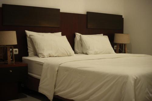 Postel nebo postele na pokoji v ubytování Hotel Graha Kinasih Kotabaru