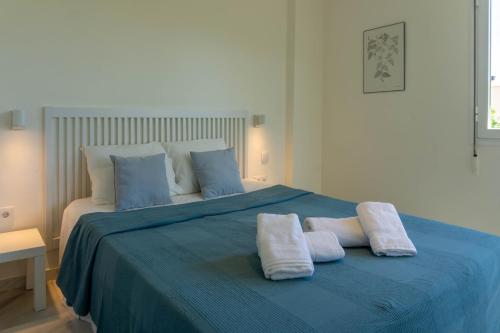 1 dormitorio con 1 cama azul y 2 toallas en Suite Añoreta Malaga Parking 101 en Benagalbón
