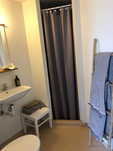 a bathroom with a sink and a shower curtain at Hotel Vestkysten in Løkken