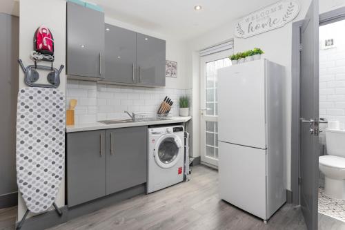 een keuken met een wasmachine en een koelkast bij Air Host and Stay - Teck House, sleeps 7, mins from Royal Hospital in Liverpool