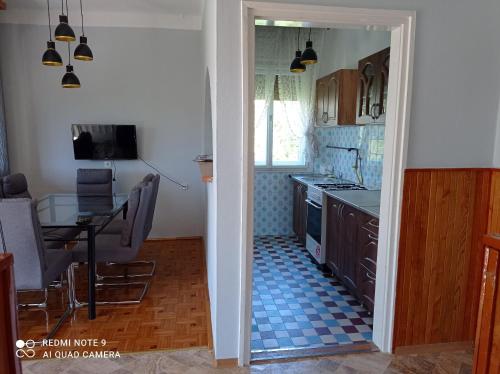 a kitchen with a table and a dining room at Mátyás király Apartman in Vonyarcvashegy