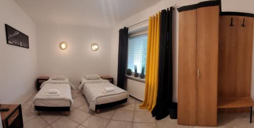 ポズナンにあるMiastkovoのベッド2台と窓が備わる小さな客室です。