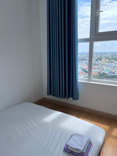 een wit bed in een kamer met een raam bij Mộc Homestay 2 phòng ngủ in Ấp Ðông An (1)
