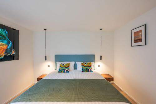 a bedroom with a bed and two pillows at unique hideaway, holiday house with large garden in Kortenaken