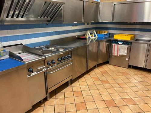 a kitchen with stainless steel appliances in a kitchen at Ostello Europa in San Vito al Tagliamento
