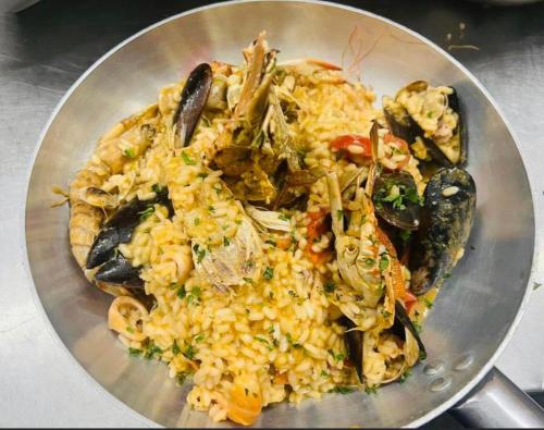 a plate of rice with mussels and other foods at CINQUE OTTAVI B&B in Santa Marinella