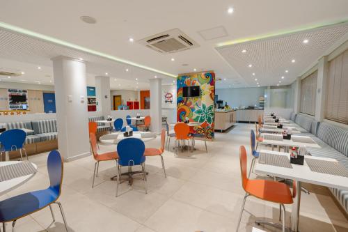 a restaurant with tables and chairs and a cafeteria at Hotel Caiuá Lago Umuarama in Umuarama