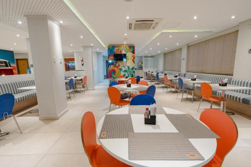 a waiting room with tables and chairs in a hospital at Hotel Caiuá Lago Umuarama in Umuarama