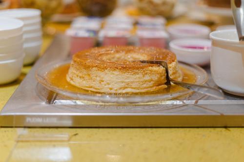 a cake sitting on a plate on a counter at Hotel Caiuá Lago Umuarama in Umuarama