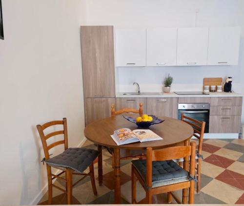 a kitchen with a wooden table with chairs and a bowl of fruit at Gemelli in Petacciato
